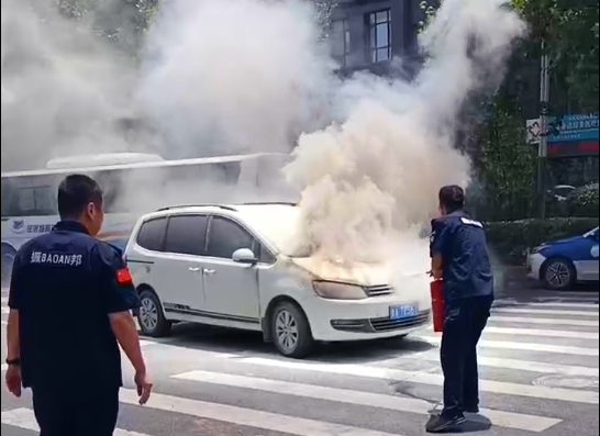  天气炎热汽车“上火”自燃，保安提起灭火器冲上前扑救 